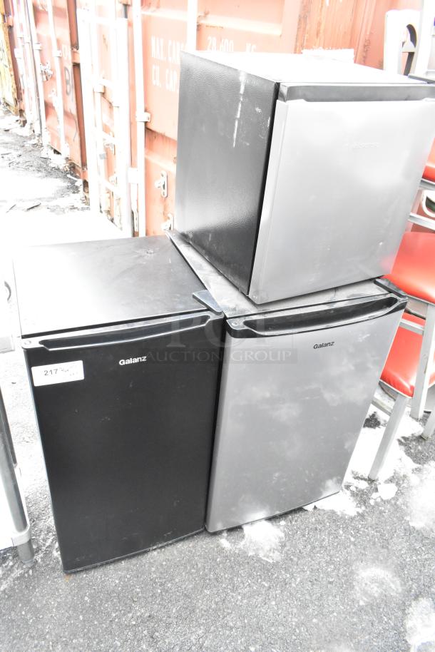 Three mini coolers: two Galanz, one Hisense, 120V, 1 Phase. Used condition, black and silver finish. Auction lot 217.