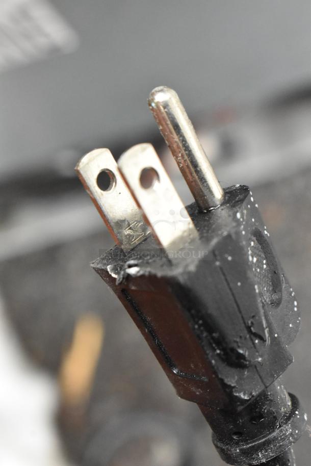 Image showing a close-up of a standard 120 volts, 1 phase plug, connected to one of the mini coolers in the auction.