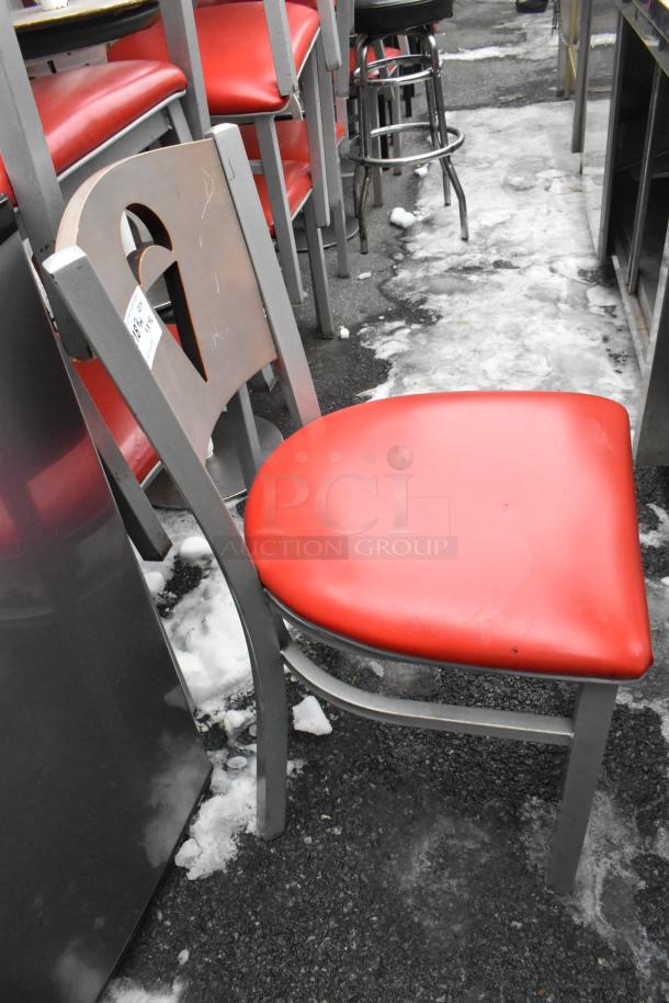 Metal dining chair with red seat cushion, featuring a heart-shaped cutout on the back. Solid condition. Auction lot tag visible.