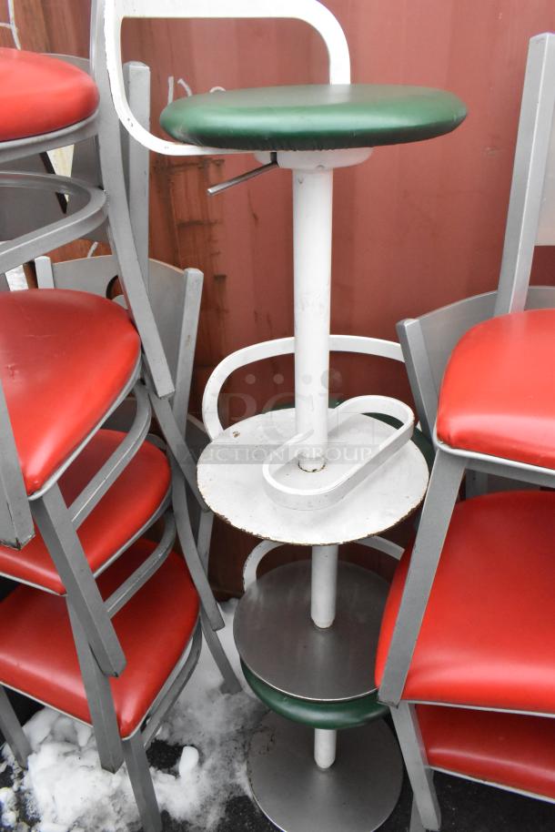 46 metal dining chairs with red cushions and a green stool, stacked. Seating shows moderate wear. Auction item, 46x bid.