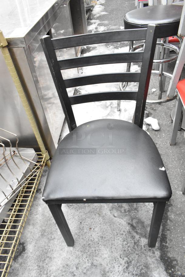 Metal dining chair with black frame, slightly worn black seat cushion. Visible scuffs, part of 46-piece set auction.