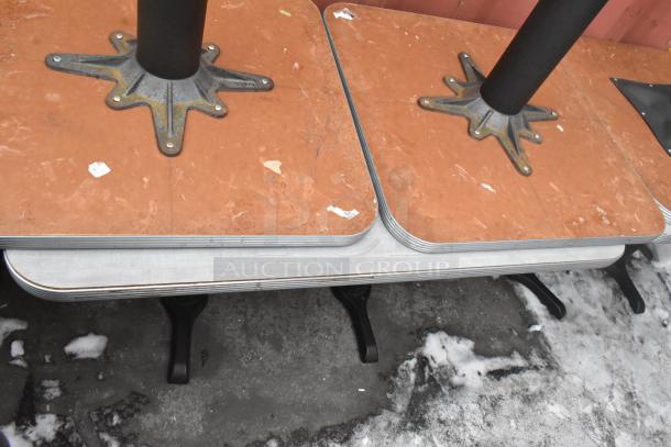 10 dining height tables with brown tops on black metal bases, showing minor wear.