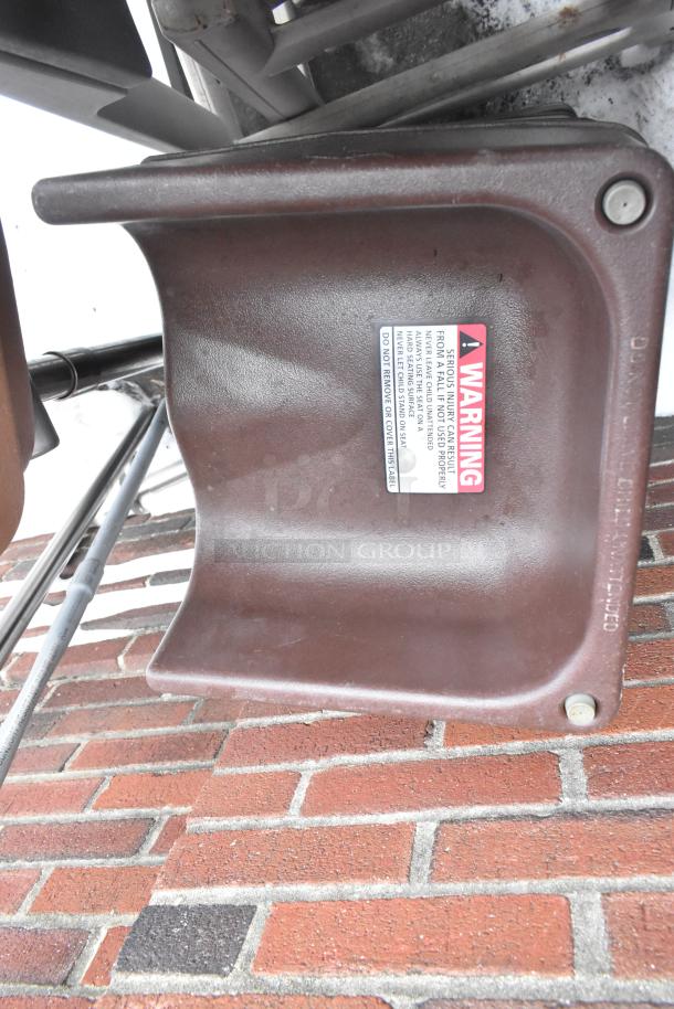 Brown booster seat with visible warning label, part of an auction set including 8 booster seats and 2 high chairs.