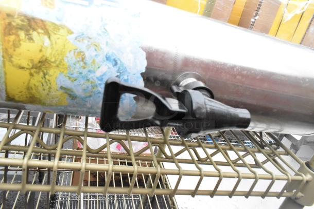 Three-tier wire shelving unit with contents, featuring a grey metal finish and a mounted container with spigot. Buyer must dismantle.