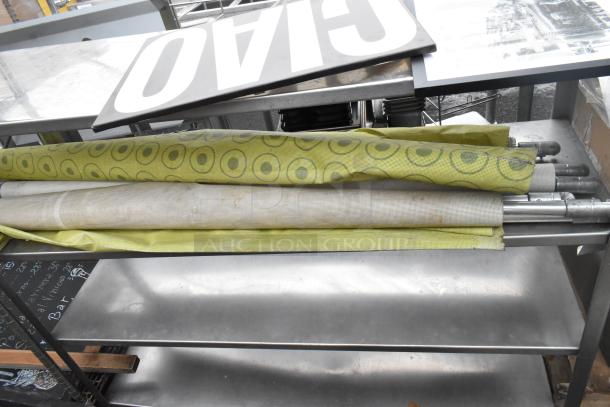 4 tier shelving unit with contents, including metal poles and rolled material. Two of the shelves hold miscellaneous items.