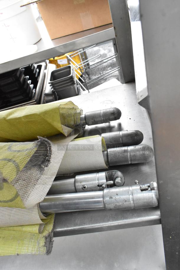 4-tier metal shelving unit with boxes, trays, and rolled fabric stored on the shelves. Sturdy condition, accessories included.