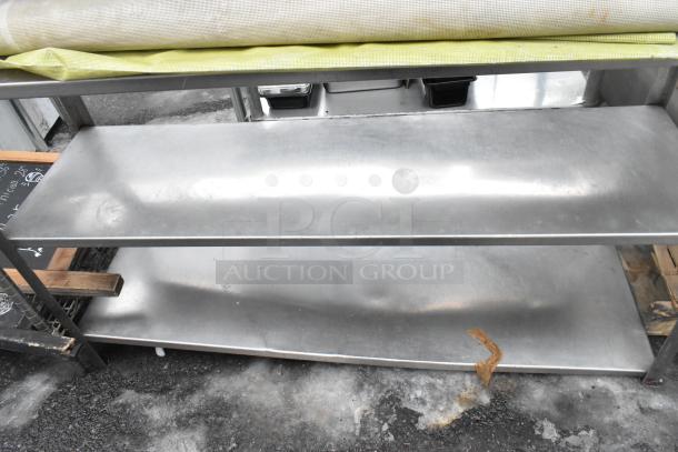 4 tier metal shelving unit with contents, visible wear, multiple shelves, includes items like trays and rolls. Sturdy construction.