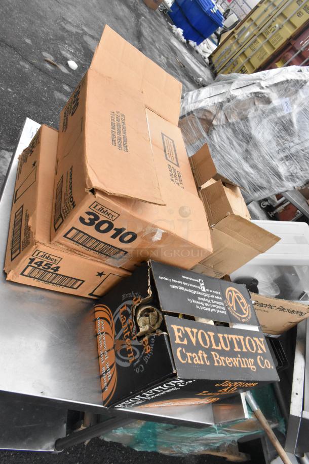 Regency 600TSB3036S table with cardboard boxes containing glasses and bowls. Boxes labeled "Libbey" and "Evolution Craft Brewing Co."