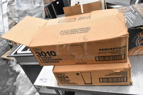 Regency 600TSB3036S table with two boxes of Libbey glasses, containing 2 and 3 dozen banquet goblets, on display.