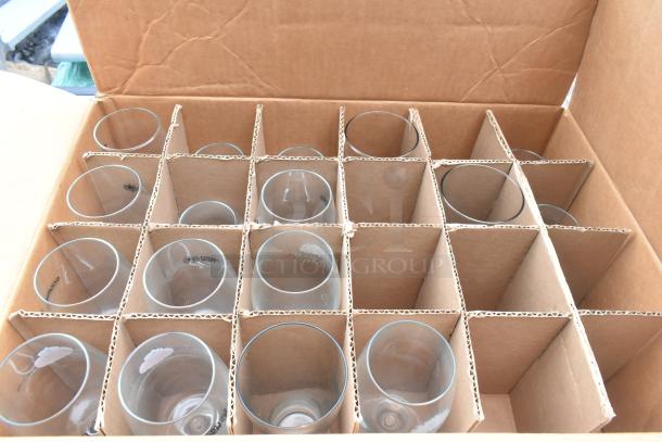 Cardboard box with dividers containing twelve clear drinking glasses.