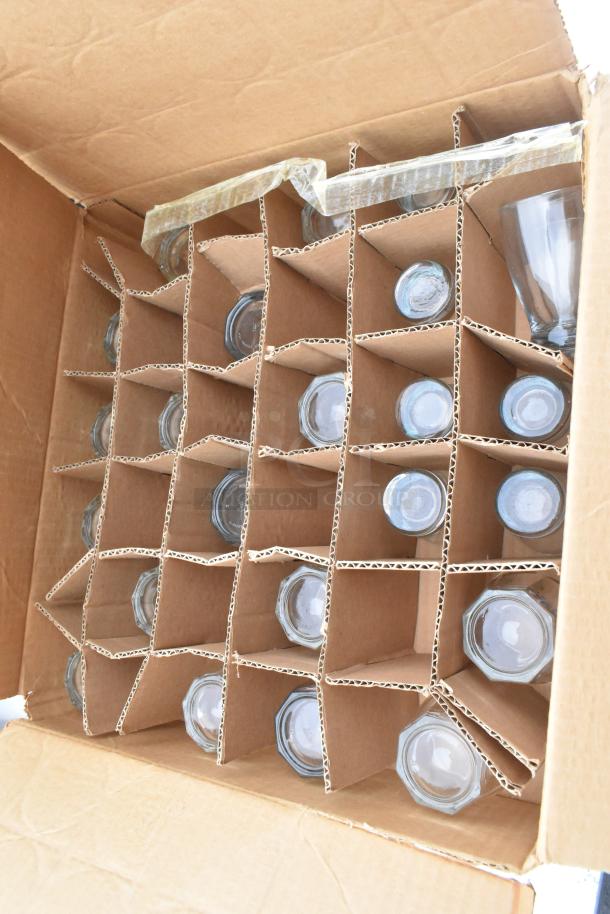 Cardboard box containing glasses, including stemmed and octagonal shapes, secured in dividers for Regency 600TSB3036S table.