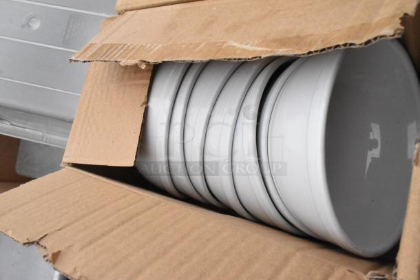 Cardboard box with stacked white ceramic bowls from Regency 600TSB3036S table set. Bowls appear new and well-packed.