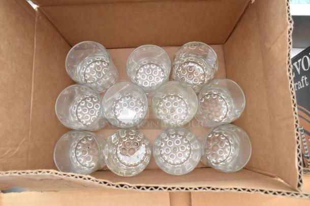 Box containing 12 clear glass tumblers with a dimpled pattern, part of Regency 600TSB3036S table set.