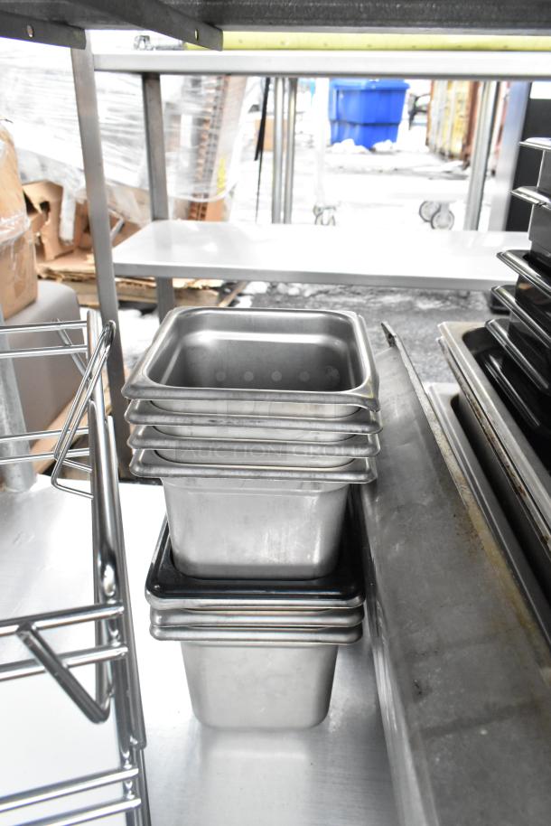 Stainless steel commercial table with under shelf. Includes metal containers. Good condition, ideal for kitchen use.