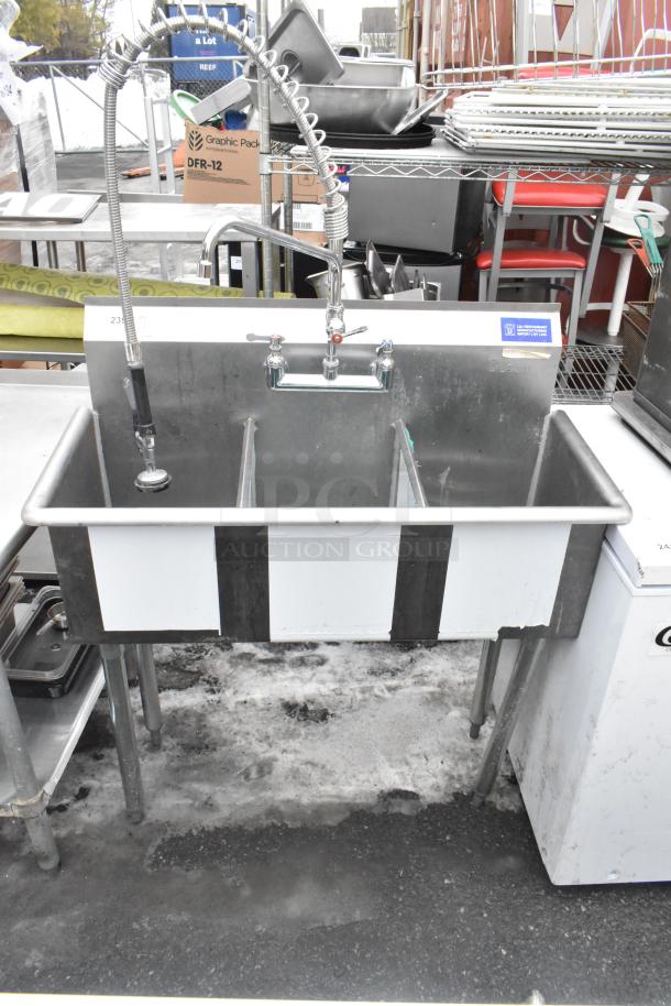 Commercial 3 bay sink with faucet, dual handles, and spray nozzle attachment. Stainless steel, used condition.