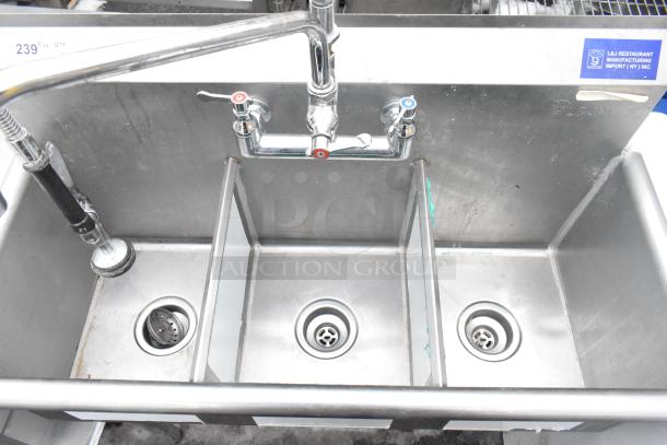 Commercial 3-bay stainless steel sink with faucet, dual handles, and spray nozzle. Used condition, ideal for industrial kitchens.