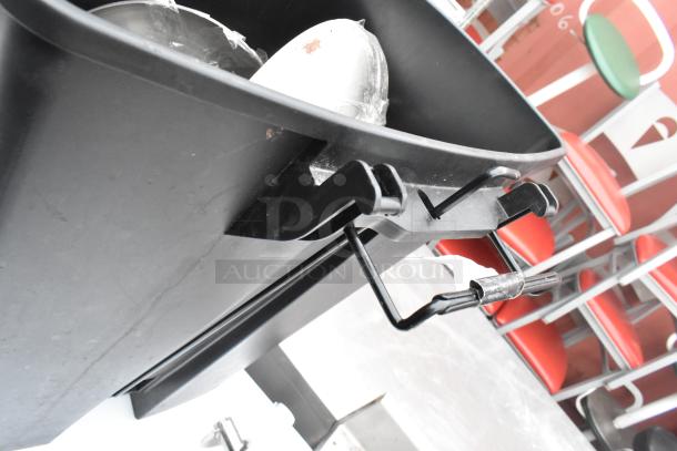 Black poly trash can with handle, visible wear. Includes chrome finish trash can, both offered at double your bid amount.