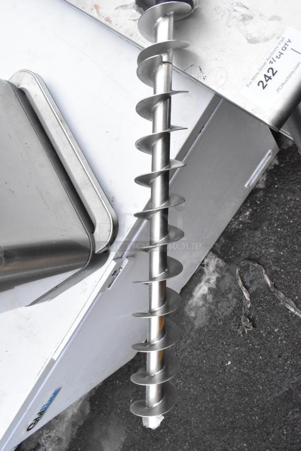 Steel auger drill resting on a metallic table with visible label "242" at top right corner.