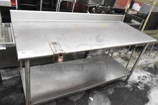 Commercial stainless steel table with backsplash, under shelf, and can opener mount. Good condition with minor surface wear.