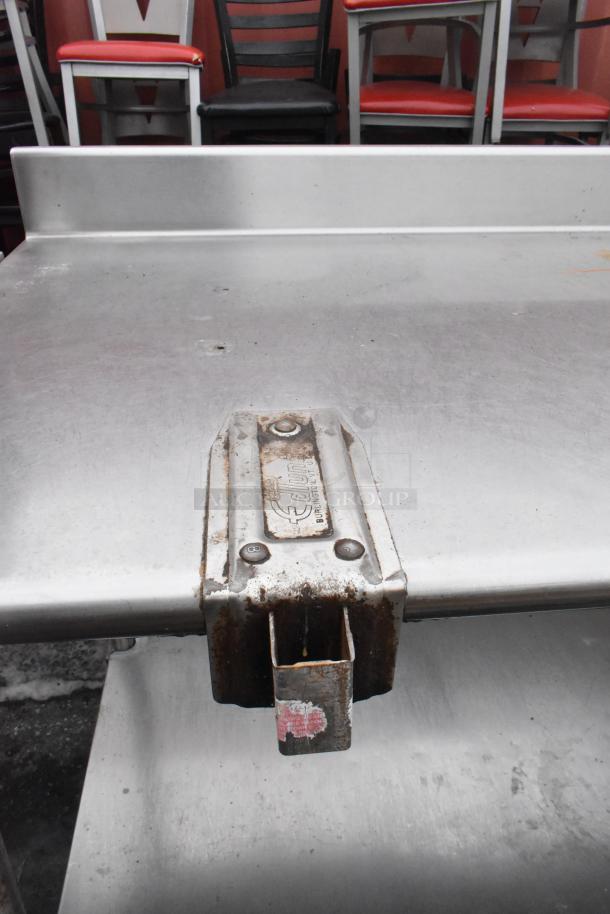 Commercial table with Edlund can opener mount, back splash, and under shelf. Stainless steel, used condition.