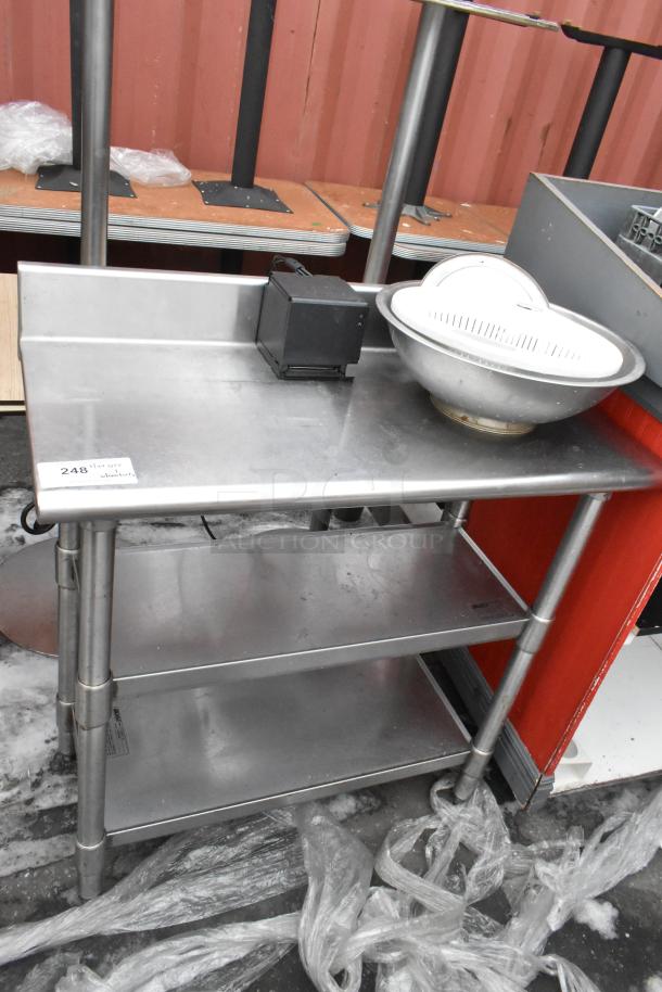 Commercial stainless steel table with backsplash, features two under shelves, Item #248, in good condition.