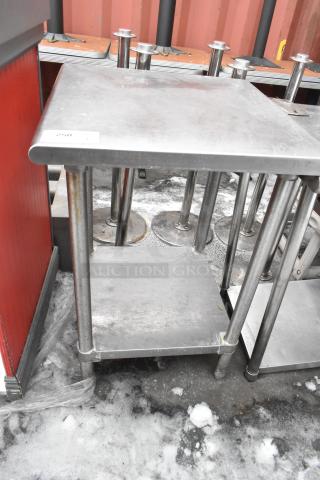 Stainless steel commercial table with under shelf, sturdy legs, slight surface wear, ideal for kitchen or workshop use.