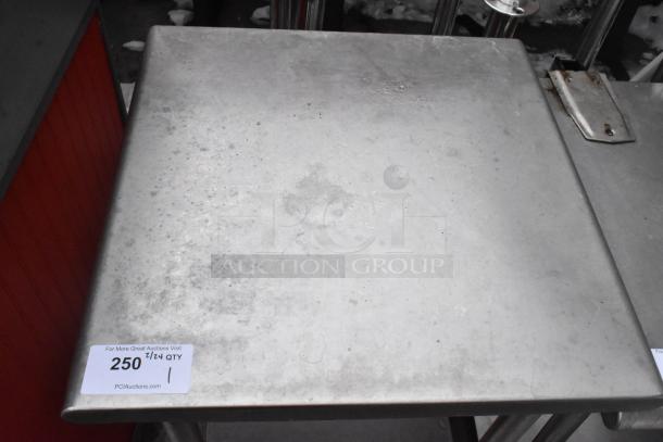 Commercial metal table with under shelf, visible wear, auction label 250. Ideal for kitchen or workshop use.