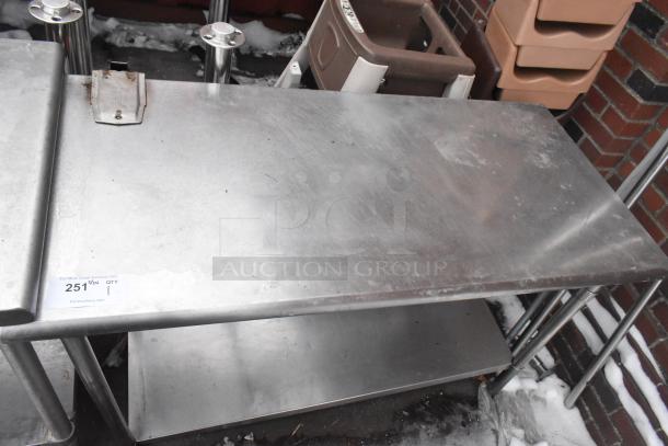 Stainless steel commercial table with mounted can opener and under shelf, pre-owned, visible wear, auction tag 2511.