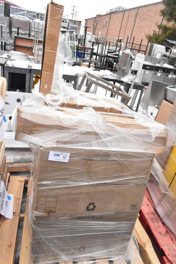 Shrink-wrapped pallet with boxed items, including anti-fatigue mat and sink. Boxes labeled "Fragile" and "Handle With Care."