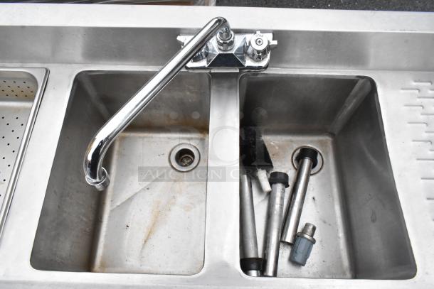 Commercial 4 bay back bar sink with dual drain boards, chrome faucets, and handles. Used condition with visible wear.