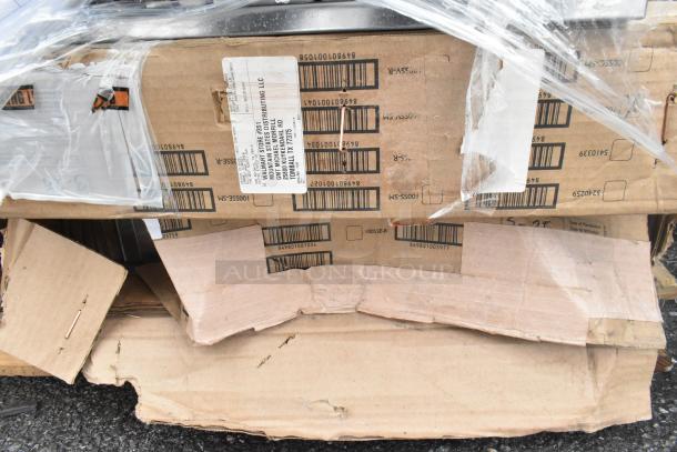 Pallet lot of various items including metal baskets, a light fixture, and a hose. Visible cardboard boxes with shipping labels.