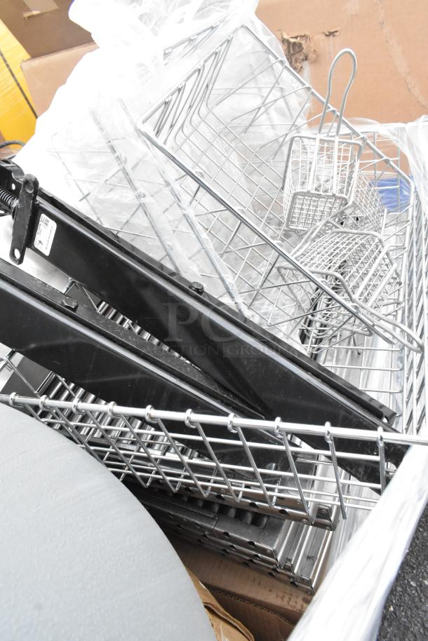 Pallet with metal baskets, light fixture, hose; mixed condition; includes black metal parts and packaging.