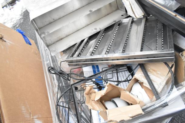 Pallet lot of assorted items including metal baskets, light fixture, hose, and cardboard boxes. Some items appear worn.