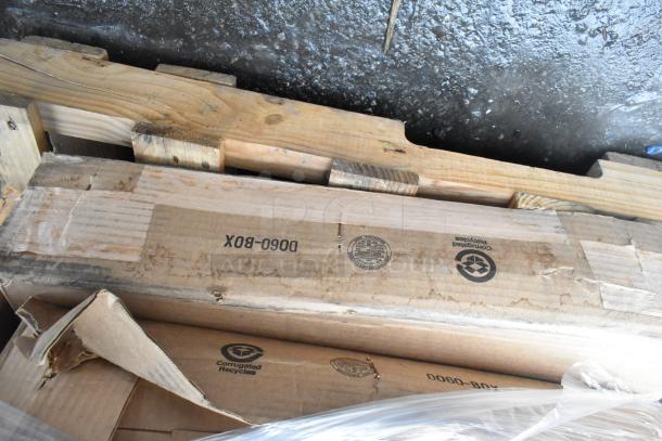 Pallet with various items including metal baskets, light fixture, and hose. Boxes marked "Corrugated Recycles," in used condition.