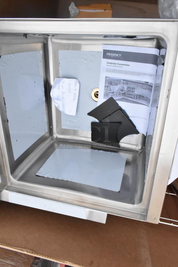 Metal utility sink with brand label "Regency," includes assembly instructions and parts. Scratch and dent condition.