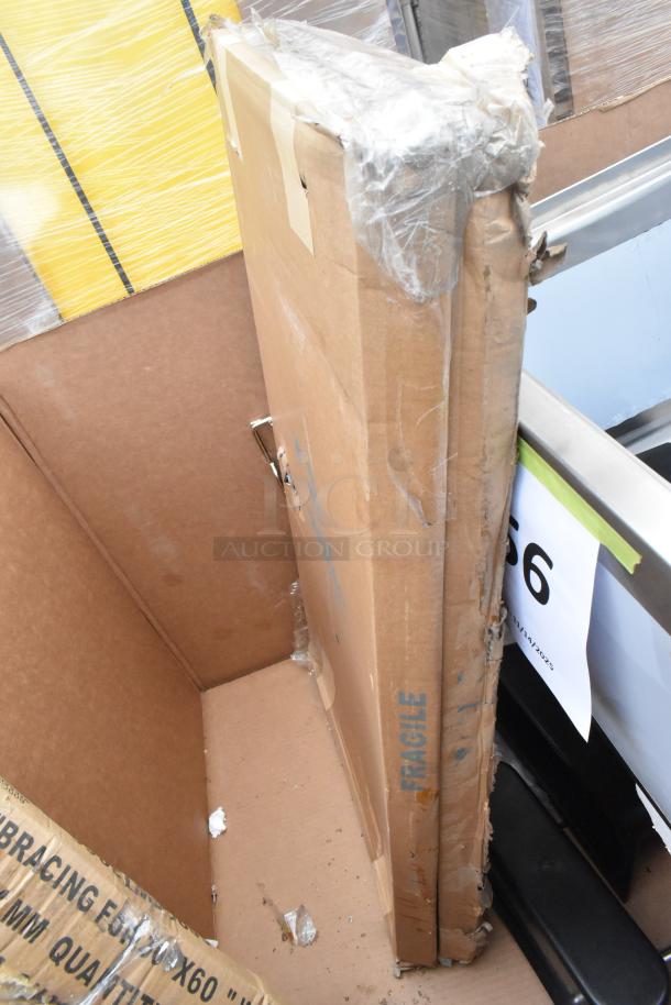 Cardboard boxes containing 6 new scratch and dent items; includes Koala Kare Infant Seat Kradles, utility sink, and ice bin. Fragile label visible.