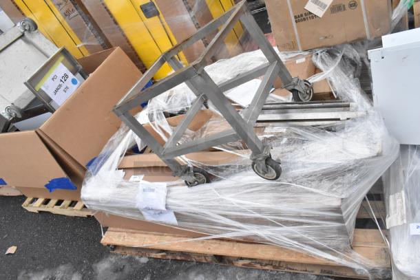 Seven brand new scratch and dent items, including Avantco overshelf and Watts grease trap, stacked and wrapped on pallets.