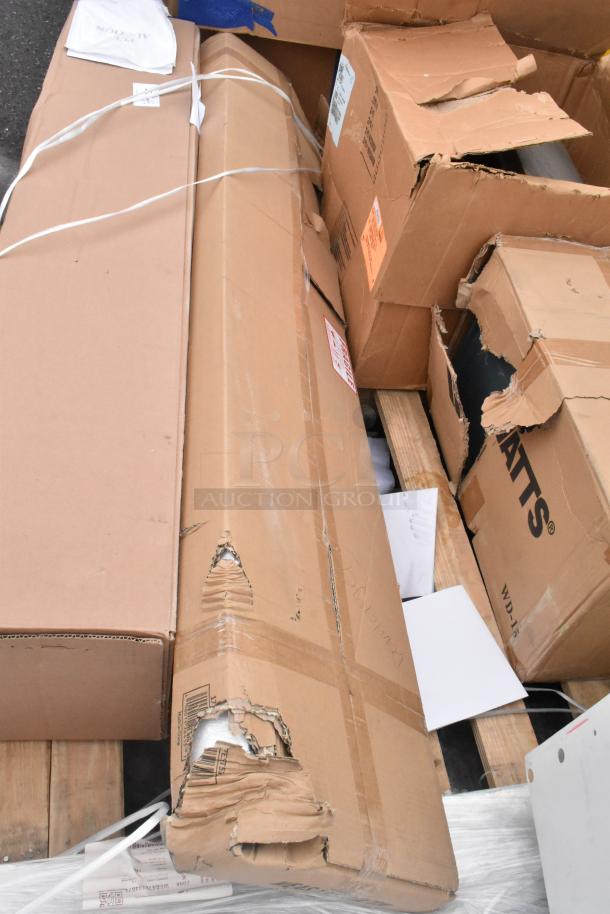 Stack of new, scratch and dent items including Avantco Over Shelf and Watts Grease Trap in original packaging, visible wear.