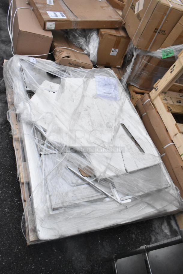Lot of brand new scratch and dent items, including WEBATL184874 unit, stacked on a pallet, wrapped in plastic.