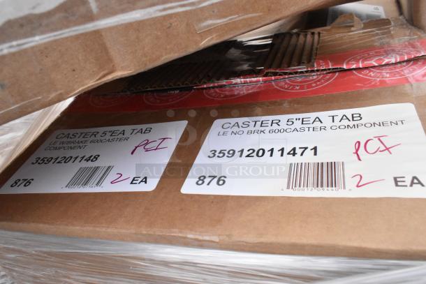 Stacks of boxed items with visible labels reading "Caster 5' EA Tab," indicating caster components. Tags show model numbers and quantities.
