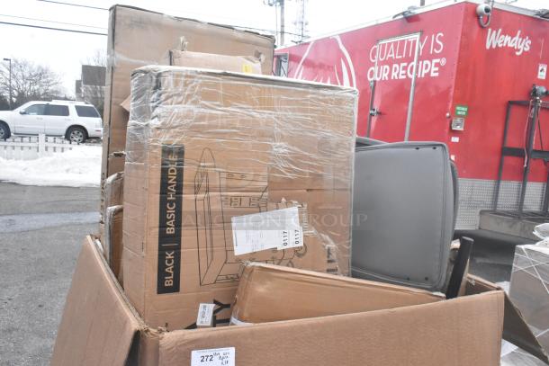 Boxes of scratch and dent items including shelves and tables, in original packaging, displayed outdoors near a red trailer.