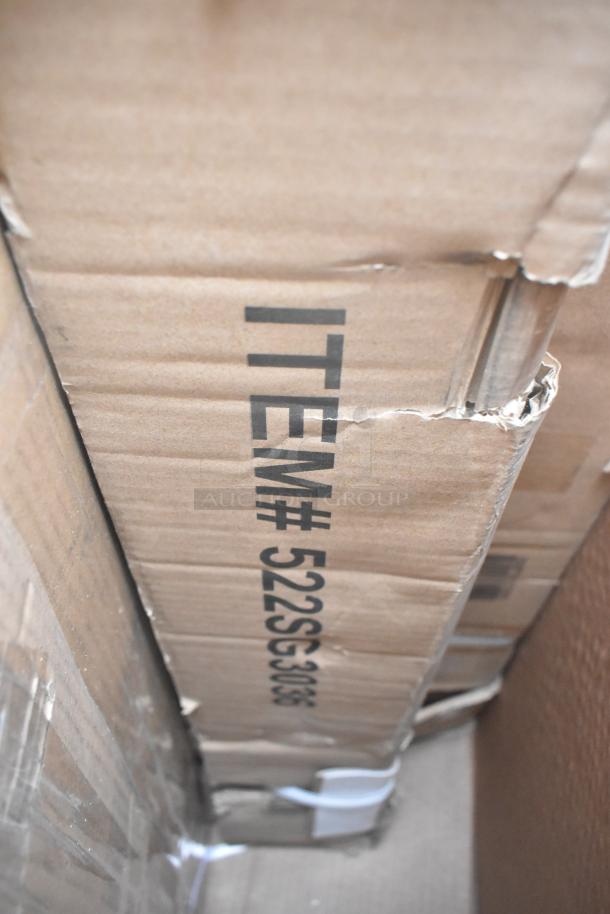Cardboard box with visible item number 522SG30135, containing a new scratch and dent lot of shelves and work tables.
