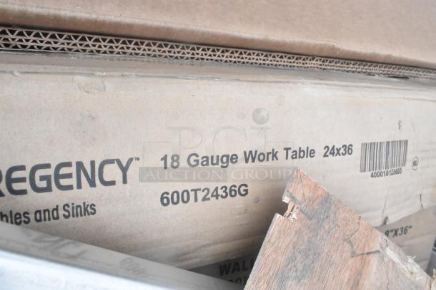 Box labeled "Regency 18 Gauge Work Table 24x36" with visible model number 600T2436G and barcode, indicating new scratch and dent items.