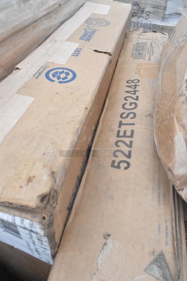 Cardboard boxes containing scratch and dent items marked "522ETSG2448"; visible dents and scuffs.