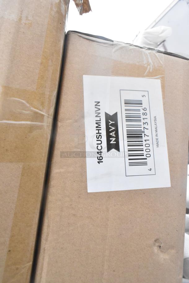 Cardboard box with label "164CUSHMLNVN Navy" and barcode, marked "Made in Malaysia." Box shows minor damage.