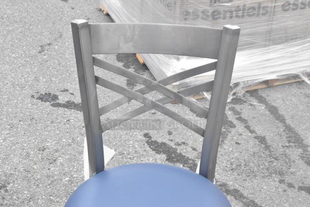 Metal chair with crisscross back design and blue seat cushion, brand new scratch and dent condition.