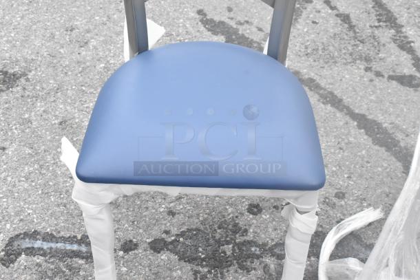 Brand new chair with blue seat cushion, minor scratches, partially wrapped, on pavement. Part of a scratch and dent lot.