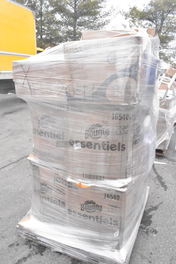 Pallet of assorted items including Bounty Essentials paper towel rolls, all wrapped in plastic. Some labels visible.