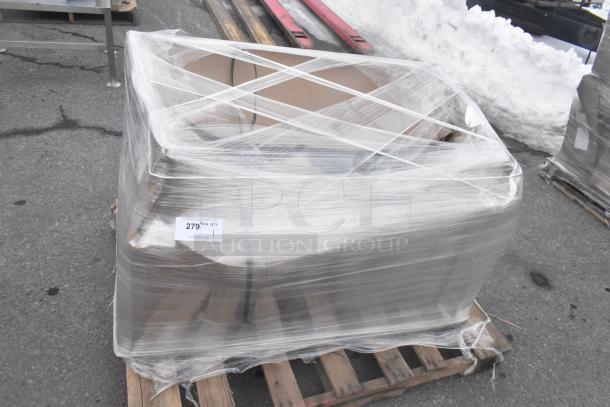 Brand new Regency 600S21824 sink, scratch and dent, wrapped in plastic on a pallet, with auction tag visible.