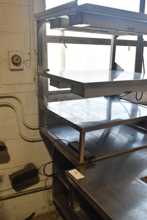 Stainless steel multi-shelf merchandiser display with warming strips. Features three shelves. Good condition.